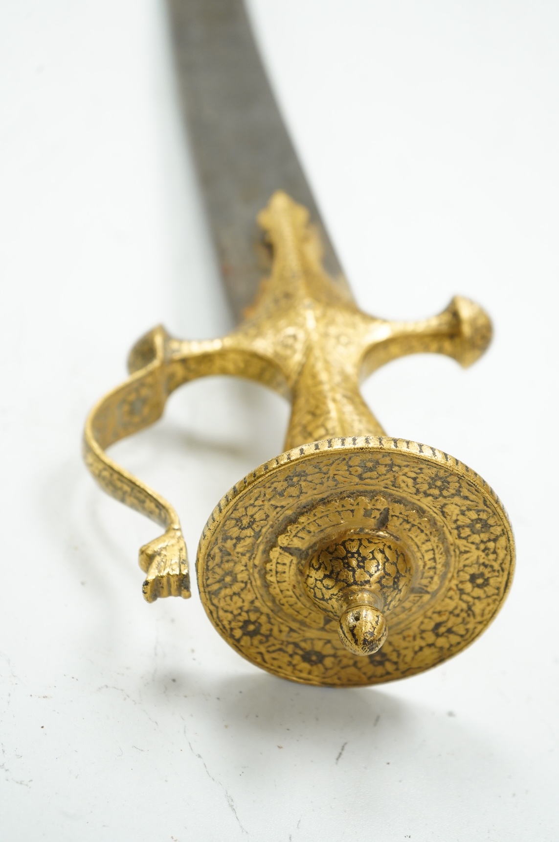 A good Indian sword tulwar, with 19th century broad curved single edge blade and iron hilt of conventional form entirely covered with flowering foliage